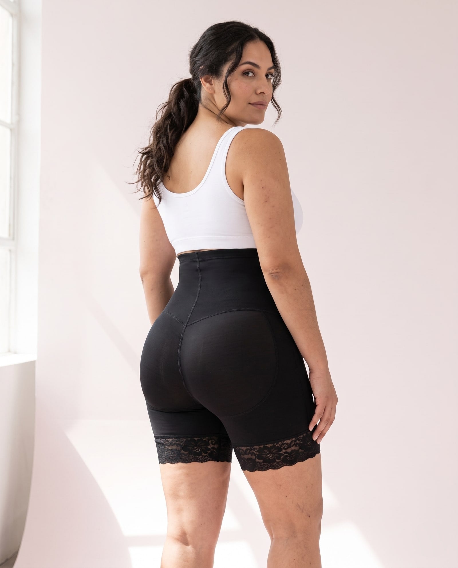 Vista de espalda de la faja short levanta cola negra con encaje en la pierna